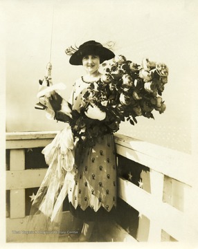 Portrait of Alice Wright Mann holding a bouquet and a bottle prior to the christening of the U.S.S. West Virginia.
