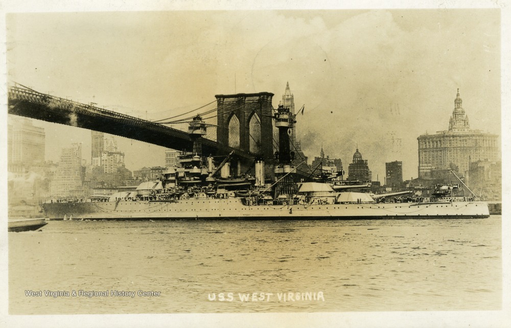 Postcard of the U.S.S. West Virginia going under the Brooklyn Bridge.