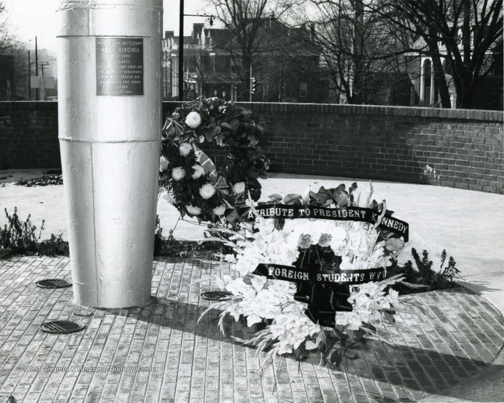 Shown here are two wreaths placed at the bottom of Mast in Memorial Plaza.  One wreath has 'A Tribute to President Kennedy from Foreign Students WVU'.