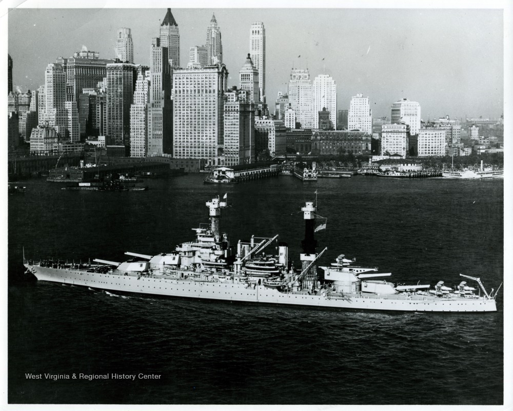 An aerial oblique view of U.S.S.  West Virginia in East River, with New York City in background.