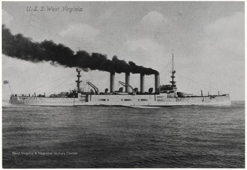 Steam billows from the ship's steam towers. An American flag hangs from a mast in the rear. 