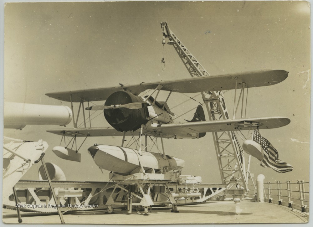 The plane sits on the battleship's deck. 