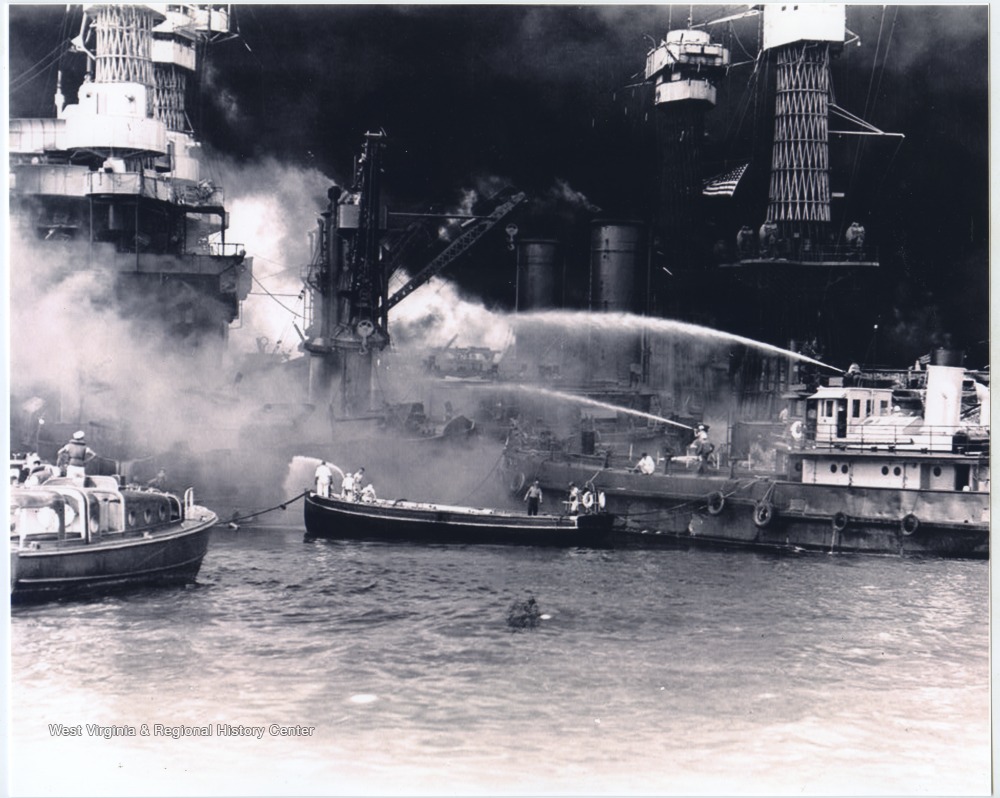 Men on boats attempt to extinguish the fire on the U.S.S. West Virginia.